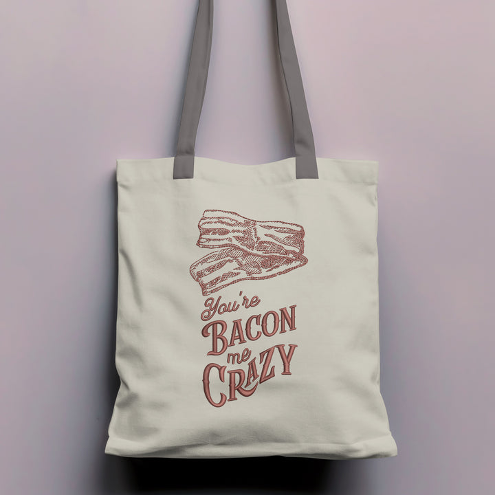 Photograph of a tote bag featuring You're Bacon Me Crazy design