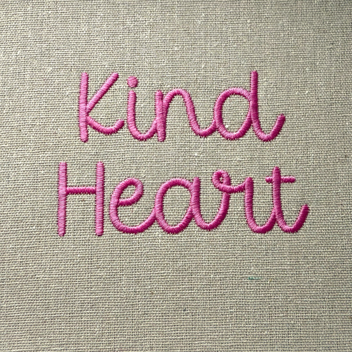 Photograph of stitched out Kind Heart embroidery font