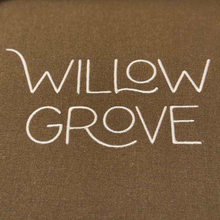 Text 'WILLOW GROVE' embroidered on a brown fabric background