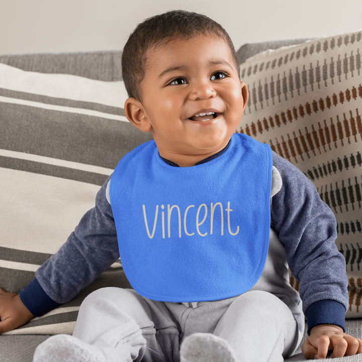 Photograph of a baby wearing a bib featuring Fresh Eggs font